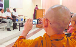 A student takes a picture during a programme organised by the Department of Buddhist Studies in Jammu University on the occasion of Buddha Purnima on Thursday.