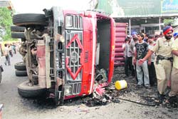 Passersby watch curiously at the truck that crushed a man to death at Samrala Chowk in Ludhiana on Thursday.