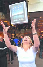 A woman poses for pictures as she celebrates buying an 'iPad' from an Apple store in central London on Friday.