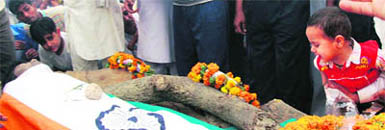 Two-year-old Nandu, son of Army jawan Husan Singh, who died on duty in Congo while on a peace mission, at the cremation of his father at Baraas village in Karnal district on Friday.