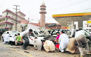 Pakistani mediapersons take cover outside one of two mosques stormed by gunmen in Lahore on Friday.