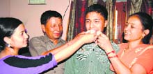 Rahul Rawat, with his parents and sister, celebrates his 10th rank in the state board examinations in Haridwar on Saturday.