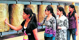 Tourists spin prayer wheels outside the Dalai Lama temple at McLeodganj on Sunday.