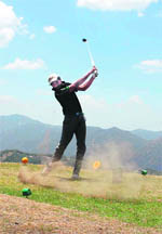 A golfer tees off during the second season of the Carlsberg Golf Tournament held at Naldehra, 20 km from Shimla, on Sunday.
