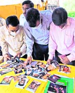 Anxious relatives try to identify their kin from photographs of the victims of the Gyaneswhari Express mishap at a hospital in Midnapore on Sunday.