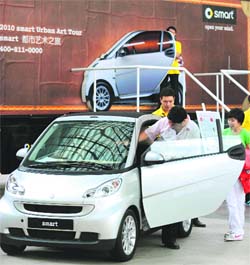 A man sits inside a Smart car at a promotional event outside a shopping mall in Beijing on Monday.