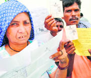 Dalit families from Mirchpur (Hisar) showing their identity proof in New Delhi on Monday. 