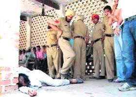 Brutality: Gurdev Singh lies unconscious on the district court premises in Ferozepore after being allegedly beaten up by policemen