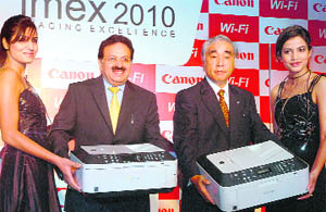 President and CEO of Canon India Kensaku Konishi (2nd R) and senior vice-president Alok Bhardwaj (2nd L) along with models pose with Wi-Fi-enabled all-in-one printers at their launch in New Delhi on Tuesday.