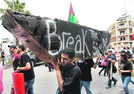Palestinians carry a mock ship during a protest in downtown Ramallah a day after a deadly raid by Israels navy on an aid flotilla bound for the Gaza Strip, on Tuesday.