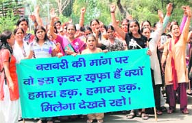 Activists of various NGOs raise slogans in favour of 33 per cent reservation for women during a rally at Dharamsala