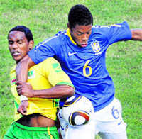 M Bastos (R) of Brazil vies for the ball with Quincy Antipas of Zimbabwe on Wednesday