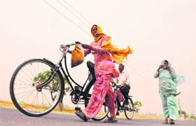 Women brave a dust storm that hit Ludhiana on Thursday morning.