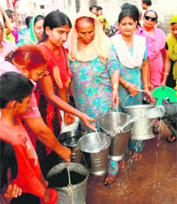 Women line up to fill water from a private water tanker at Dadu Majra village on Friday.