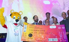 Lt. Governor of Delhi Tejendra Khanna (R), together with President of the Indian Olympic Association (IOA) Suresh Kalmadi, Archery Association of India president Vijay Kumar Malhotra and Shera (L), the mascot of 2010 Commonwealth Games, poses with a CWC ticket during the launch of Commonwealth Games ticket sales in New Delhi