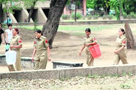 Women constables carry buckets to fetch water for those who appeared in the ASI recruitment test held in University of Jammu