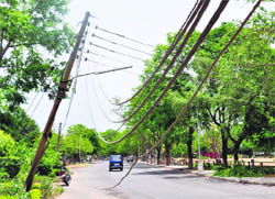 Electricity wires dangle in the middle of the road at Sector 27, Chandigarh,on Saturday.