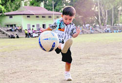 A budding footballer plays during the recess of a football tournament in Dehradun on Saturday.
