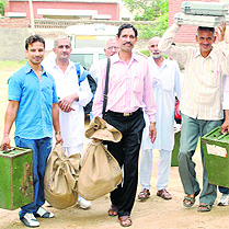 Polling staff carry EVMs and other material for the elections in Bhiwani on Saturday.