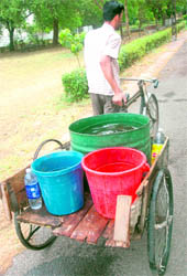 A man ferries buckets to supply water in areas 
