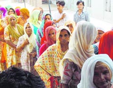 Women wait for their turn to vote in a village near Sirsa on Sunday.