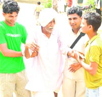 Youths help an elderly man to go to polling station in Bhiwani district on Sunday.