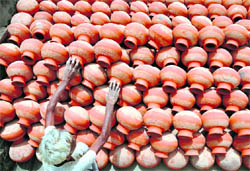 A potter tends to his earthen pots as sales pick up in summer in Ludhiana
