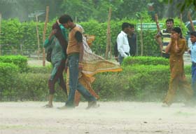 People shield themselves from dust storm near the India Gate in New Delhi