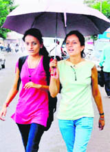 Girls enjoy a walk in the rain in Haridwar on Monday.