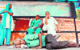 An old man takes a nap at a bus stop shelter near Civil Hospital in Karnal