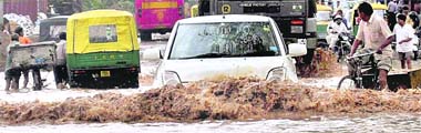 A car crosses a flooded road in Industrial Area, Phase I, Chandigarh
