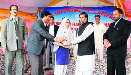 Minister for Forests and Environment Mian Altaf Ahmad (second from right) gives a prize to a schoolgirl for participating in a programme organised by the Directorate of Field Publicity in Anantnag.