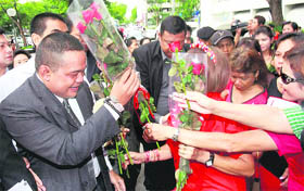 Jatuporn Prompan (left), leader of the United Front for Democracy Against Dictatorship (Red Shirts movement) is welcomed by supporters as he arrives at a criminal court in Bangkok on Tuesday. 
