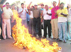 Activists of the Hindu Sikh Jagriti Sena burn effigies of the judicial system and Union Law Minister Veerappa Moily in Ludhiana on Wednesday.