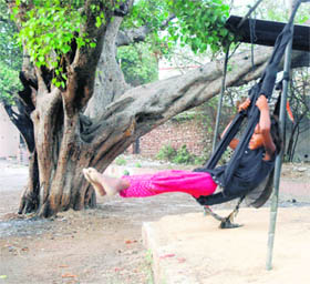 A girl enjoys herself on a swing behind Mata Kali Temple in Patiala on Wednesday.