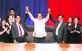 Family members cheer as Philippine lawmakers raise the hands of Benigno Aquino (centre) during his proclamation as the 15th president of Philippines at Manila