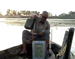 Illicit liquor is being filled in a container in a boat in the Sutlej river