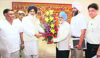 Punjab Chief Minister Parkash Singh Badal presents a bouquet to Deputy Chairman of the Planning Commission Montek Singh Ahluwalia during a meeting in New Delhi