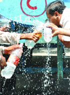 People fill bottles from a roadside tanker as the temperature rises once again in New Delhi on Thursday.