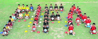 Young footballers form a chain ahead of the FIFA Football World Cup at the Nahar Singh Football ground in Faridabad on Wednesday.