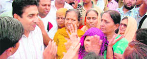 Ashwani Maingi, Tohana SDM, tries to pacify protesters at Jakhal Mandi.