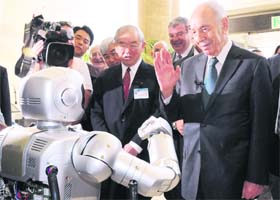 Israeli President Shimon Peres (R) is greeted by a humanoid robot Hubo upon his visit to the Korea Advanced Institute of Science and Technology (KAIST) in Daejeon, about 160 km south of Seoul