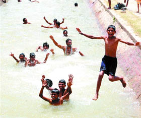Children enjoy a dip in canal water in Amritsar. 