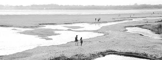 People walk on a patch that once used to be part of Sukhna Lake