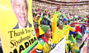 South Africa supporters hold a portrait of former President Nelson Mandela prior to the kick-off of their match against Mexico in Johannesburg on Friday. The match ended in a draw.