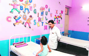  A child looks at cartoons on a wall of District Hospital, Gandhi Nagar, in Jammu on Friday.