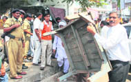 Employees of the JMC remove encroachments from the busy Bakshi Nagar market in Jammu
