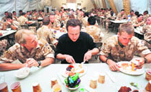 UK Prime Minister David Cameron (centre) has breakfast with British soldiers at Camp Bastion in Helmand Province during his visit to Afghanistan on Friday.