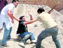 A youth being beaten up during a clash over polling in Bhuna village in Fatehabad on Saturday