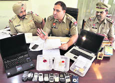 Cops show the seized mobile phones, jewellery and laptops in Ludhiana on Saturday.